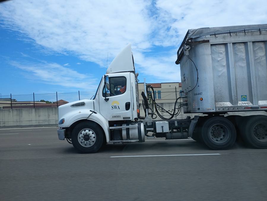 SWA Solid Waste Authority municipal dump truck on highway